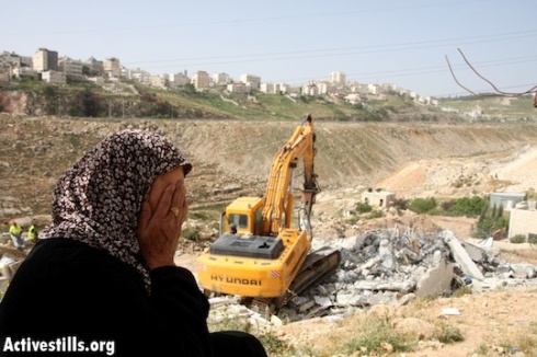 House owner weeps while Palestinian contract workers for the city of Jerusalem, demolish her house in Anata. Photo by Meged Gozani/Activestills.org